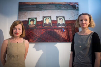 Festival attendees look on at the Cartooning for Peace exhibition part of the First World WARM (War Art Reporting Memory) festival launch in Sarajevo on June 29, 2014.