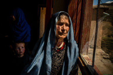 KHALID IBN WALID | BADAKHSHAN | AFGHANISTAN | 4/8/21 | Hafiza (70) pose for a portrait in her small home, revealing the open wound on her throat, that doctors believe was formed because of grieve. The family, from Palang Darra area of Yaftal Bala, an area that is now fully controlled by Taliban, were forced to leave their home and seek refuge outside of Faizabad. Four of Hafiza's sons took different paths in life. Her oldest son, Hamidullah (46) (pictured here) who had fought along Rabbani forces during the 90s, has now joined a militia group. Mullah Nourollah (44), who was formerly a teacher, joined Taliban 1.5 years back. Rahmatullah (33) and Zainuddin (27) joined ANA forces.
Hafiza took a long journey alone back to her village in Palang Darra to beg the Taliban commander to spare Mullah Nourollah and let him go home with her. He replied: "You've given two sons to the government and one to militia, this one will be ours."
