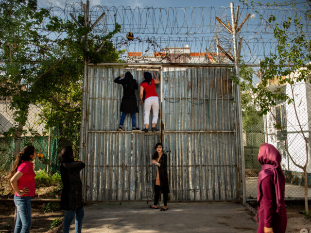 HERAT | AFGHANISTAN | 4/7/19 | Nafas (20) and another prisoner play climb the entrance gate to release the volleyball ball that was stuck in the barbed wire while the girls were playing in the courtyard.