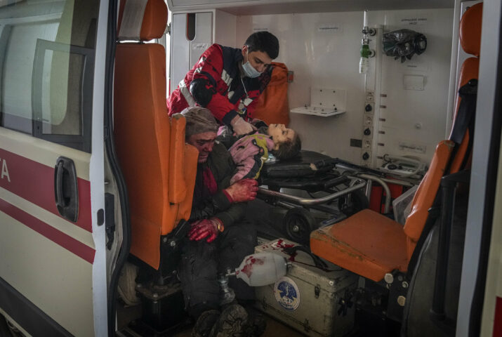 Oleksandr Konovalov, an ambulance paramedic, performs CPR on a girl injured by the shelling in a residential area as her dad sits, left, after arriving at the city hospital of Mariupol, eastern Ukraine, Sunday, Feb. 27, 2022. The girl did not survive. (AP Photo/Evgeniy Maloletka)