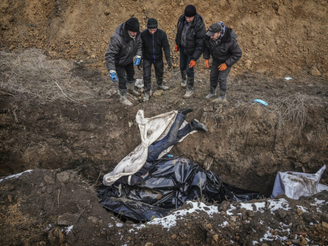 Dead bodies are put into a mass grave on the outskirts of Mariupol, Ukraine, Wednesday, March 9, 2022 as people cannot bury their dead because of the heavy shelling by Russian forces. (AP Photo/Evgeniy Maloletka)