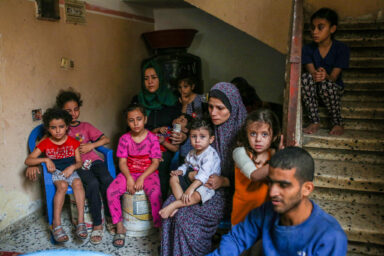 Women and children sitting at the bottom of the stairs of their neighbors’ house after their house was bombed in the middle of the AL shati camp, west of Gaza City.