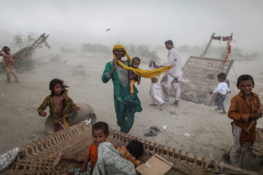 Flood victims look for shelter as a storm hits their encampment in Pakistan's Muzaffargarh district of Punjab province September 4, 2010. The flooding has destroyed cropland and livestock and displaced millions of people, causing damage the government has estimated at $43 billion, or almost one quarter of the South Asian nation's 2009 GDP.    Damir Sagolj (PAKISTAN)
