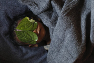 Leaves cover the face of 11 month old Rohingye refugee Abdul Aziz after his body was brought back to family shelter at Balukhali refugee camp near Cox's Bazar, Bangladesh few hours after he died December 4, 2017. Adbul Aziz, whose family fled Myanmar some two months ago, died at local clinic after suffering from high fever and severe cough for ten days, his mother said. Picture taken December 4, 2017. Damir Sagolj