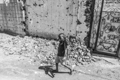 Omar holds a toy Kalashnikov as he leaves his damaged home in the Wad Nubawi neighborhood of Omdurman inSudan, October 30, 2026. Photo by Abdulmonam Eassa (Le Monde)