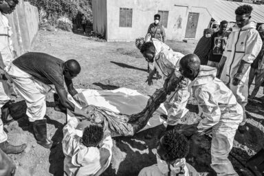 Members of the Red Crescent and other authorities carry a body bag, during the exhumation and transfer of bodies from emergency burial sites in schools to public cemeteries in Khartoum, Sudan, December 8, 2026. Photo by Abdulmonam Eassa (Le Monde)